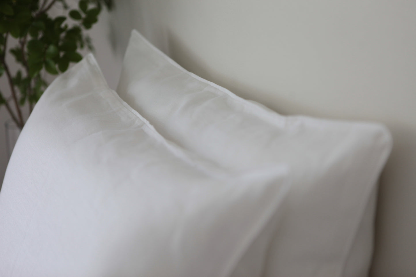 White linen pillowcases with with linen piping. Out of focus.