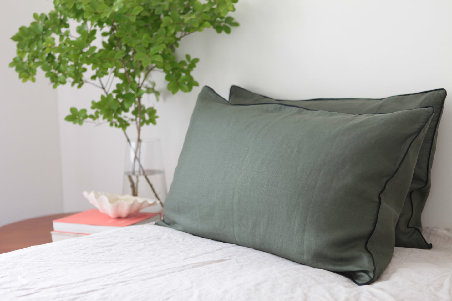 Khaki linen pillowcases with navy piping.