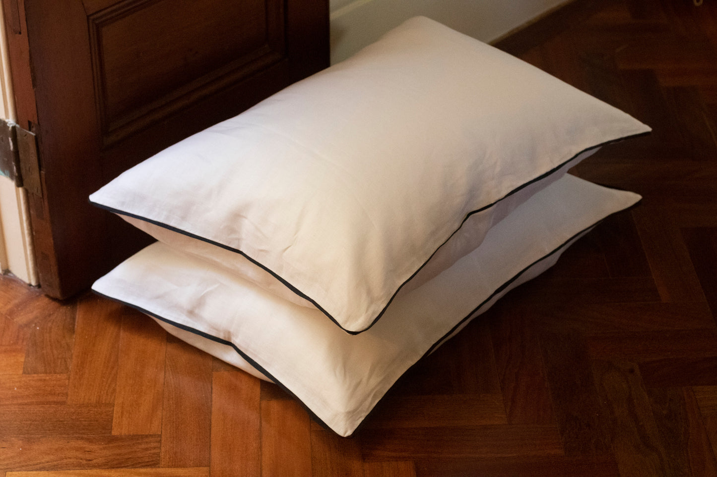 Navy linen piping on white linen body. Two pillowcases stacked.