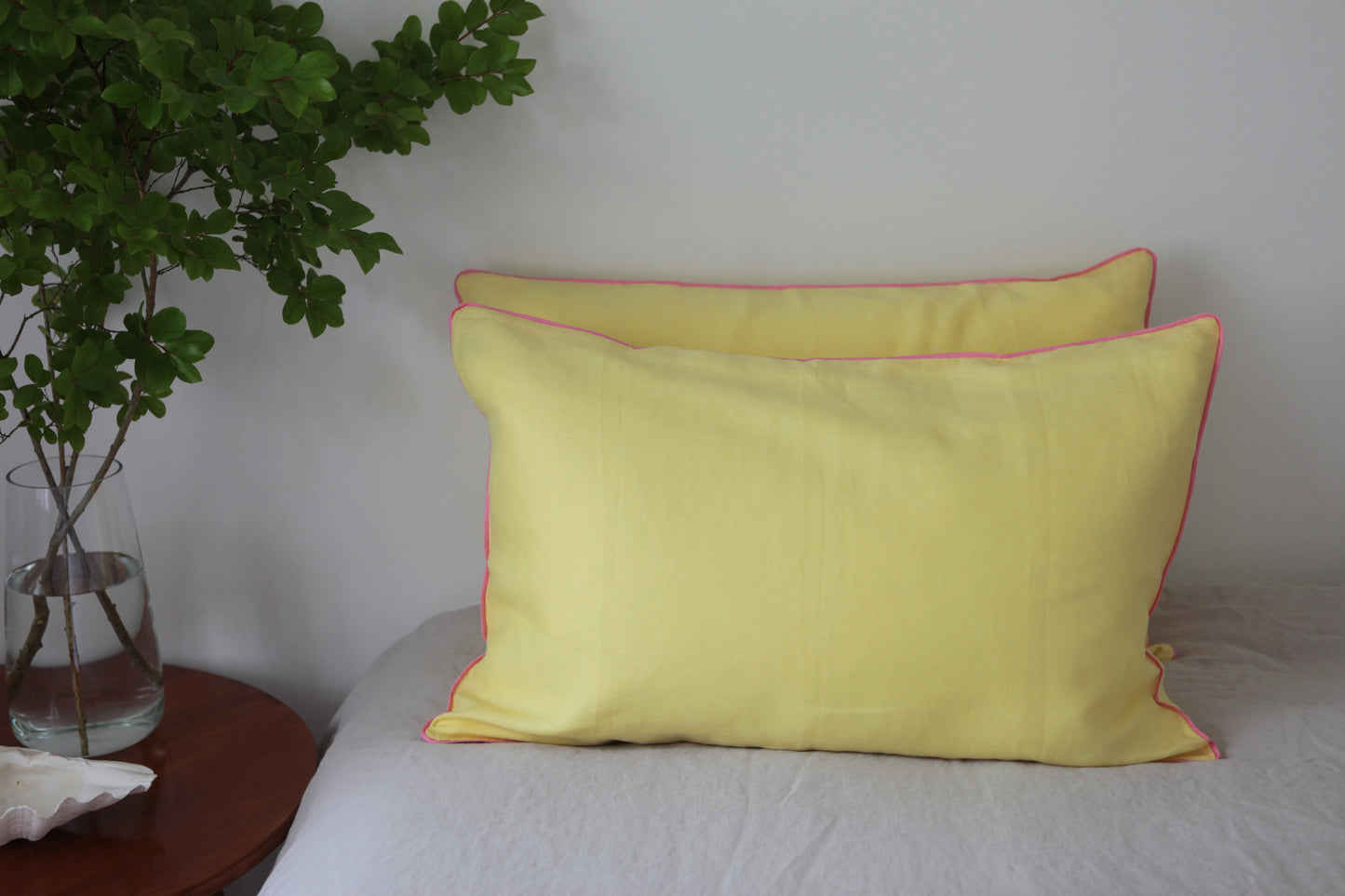 Lemon linen pillowcases with baby pink piping. Front on photo.
