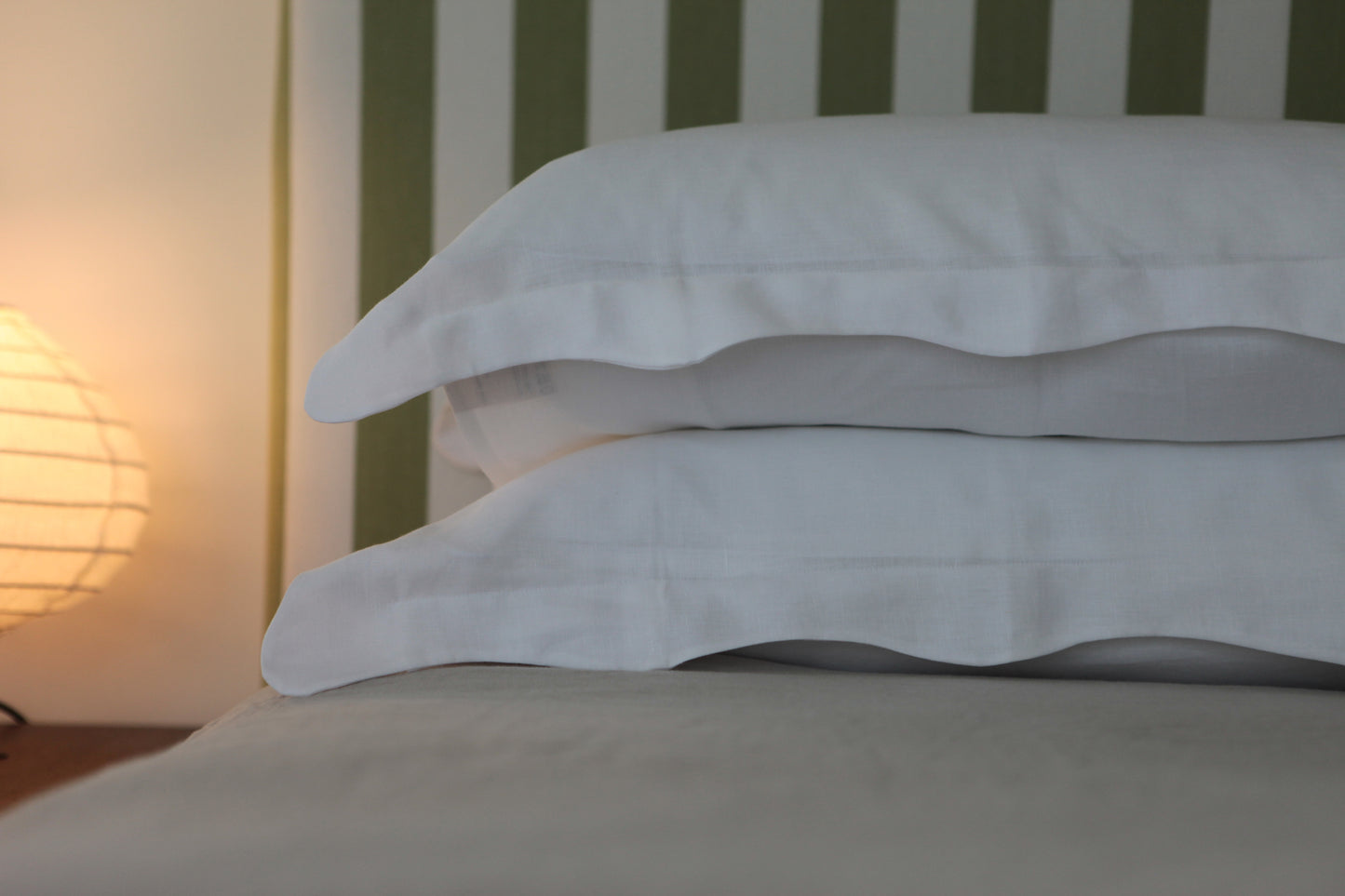 White linen pillowcases with organic wave edge. Light in background.
