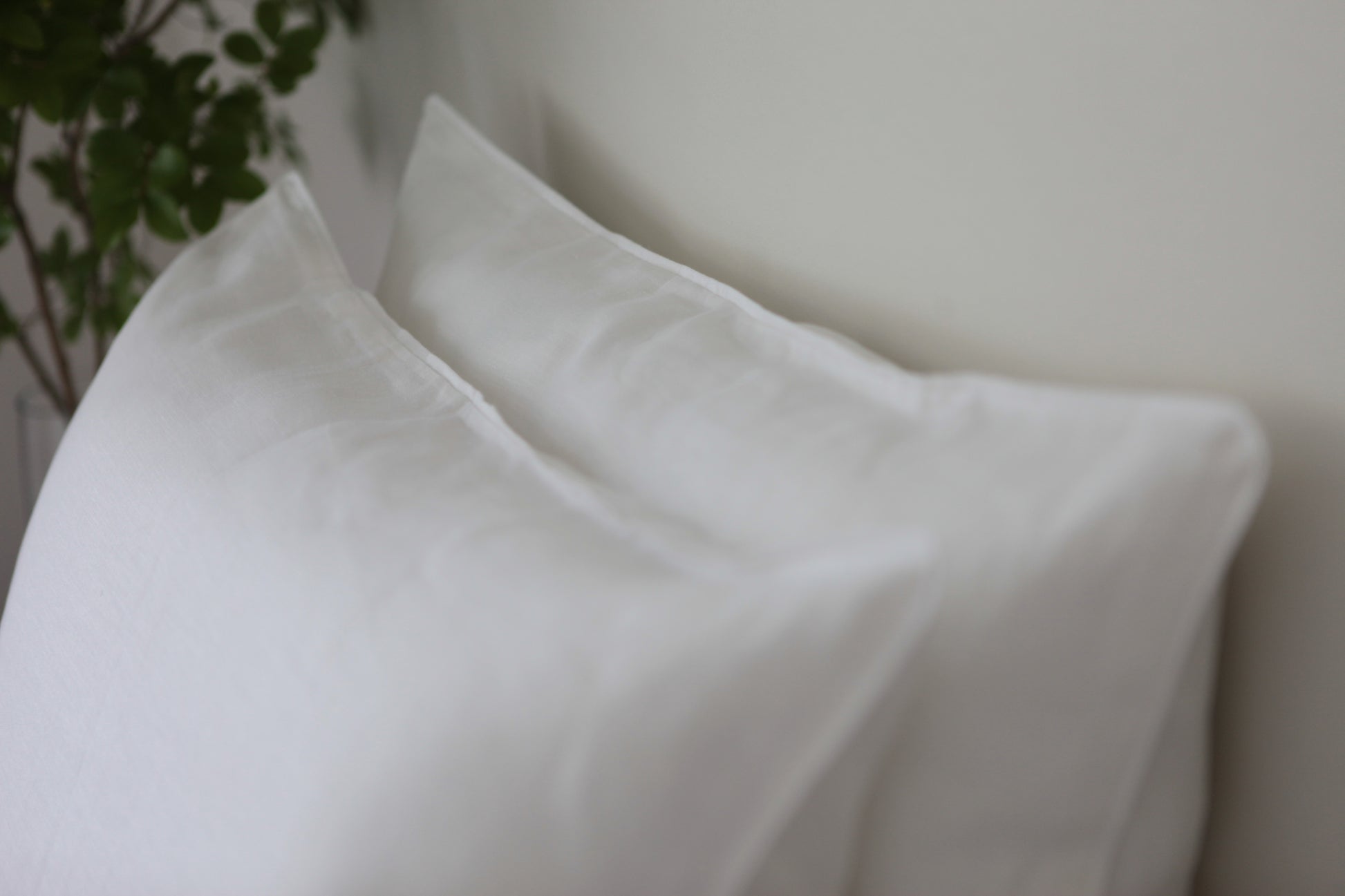 White linen pillowcases with with linen piping. Out of focus. 