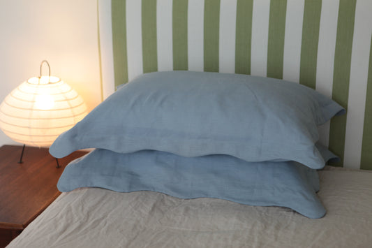 Sky blue linen pillowcases with organic wave edge border. Front on photo.