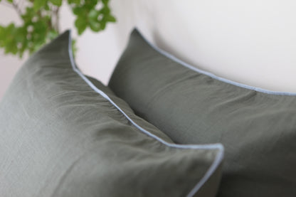Khaki linen pillowcases with sky blue linen piping. Close up photo. 