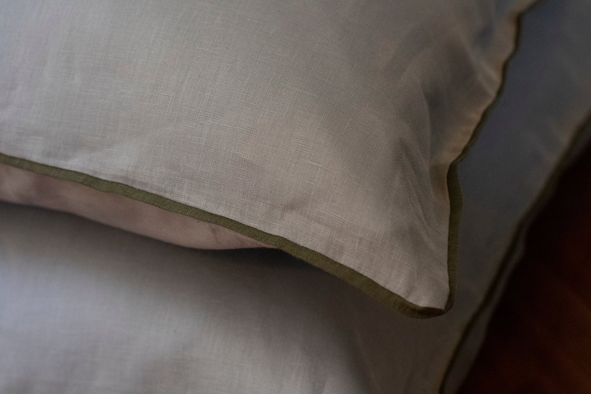 Close up image of khaki linen piped edge with sky blue linen body. 