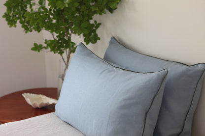 Sky blue linen pillowcases with khaki linen piping. Side photo. 