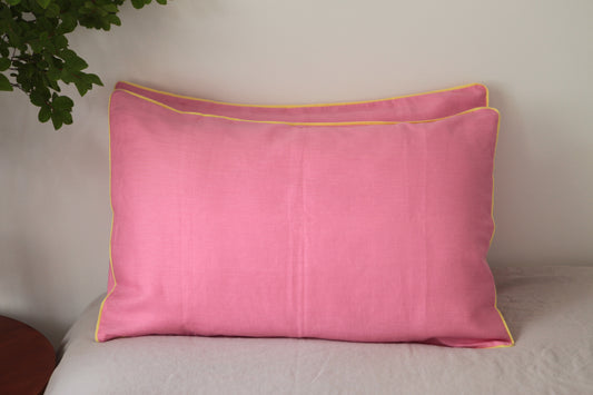 Baby pink linen pillowcases with lemon linen piping. Front on shot. 