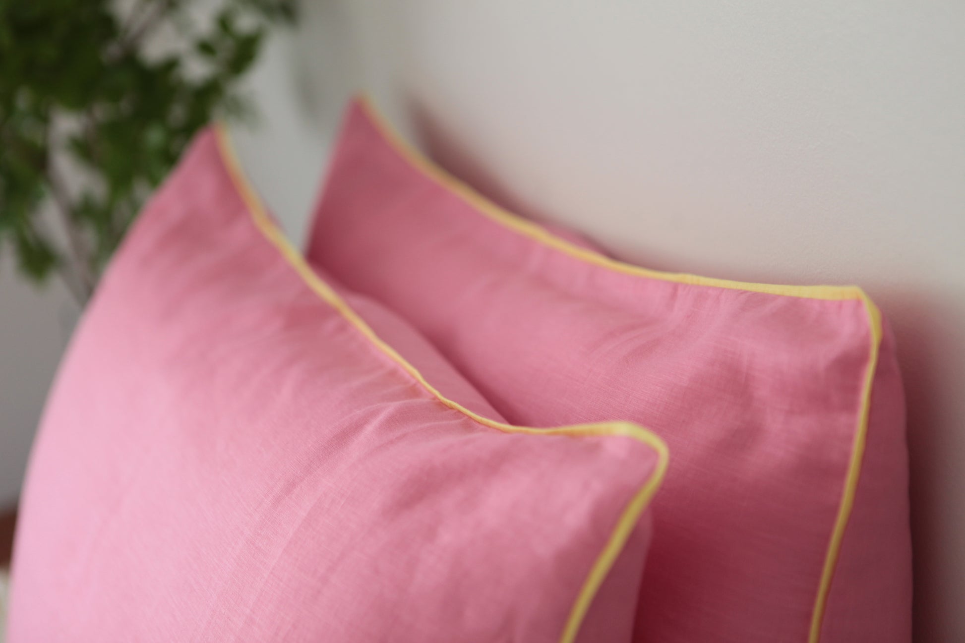 Baby pink linen pillowcases with lemon linen piping. Close up shot of piping.