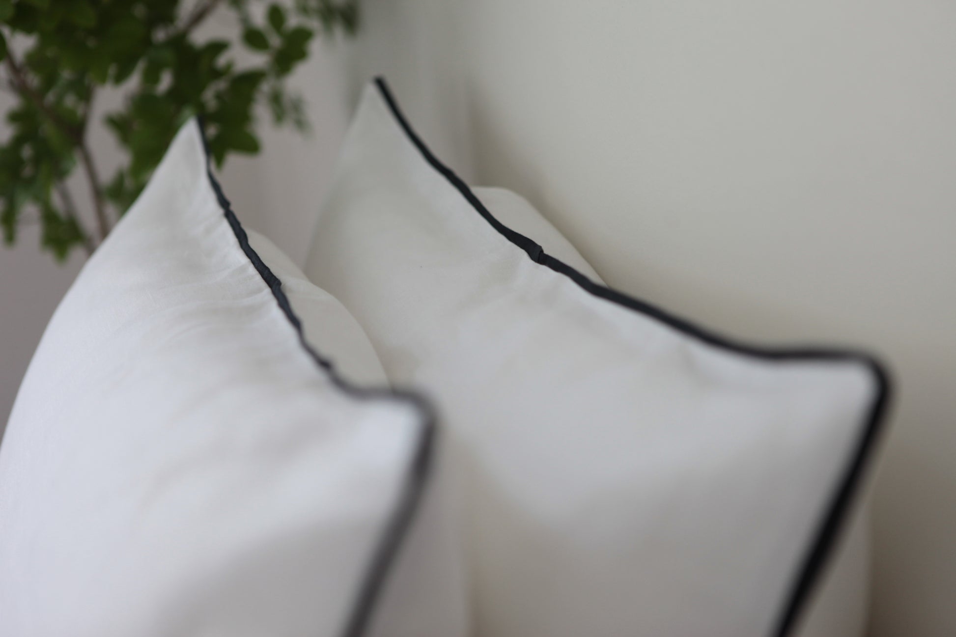 White linen pillowcase with navy blue linen piping.