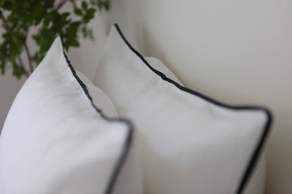 White linen pillowcase with navy blue linen piping.