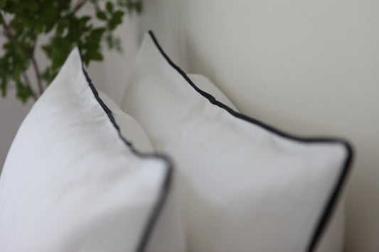 White linen pillowcase with navy blue linen piping.