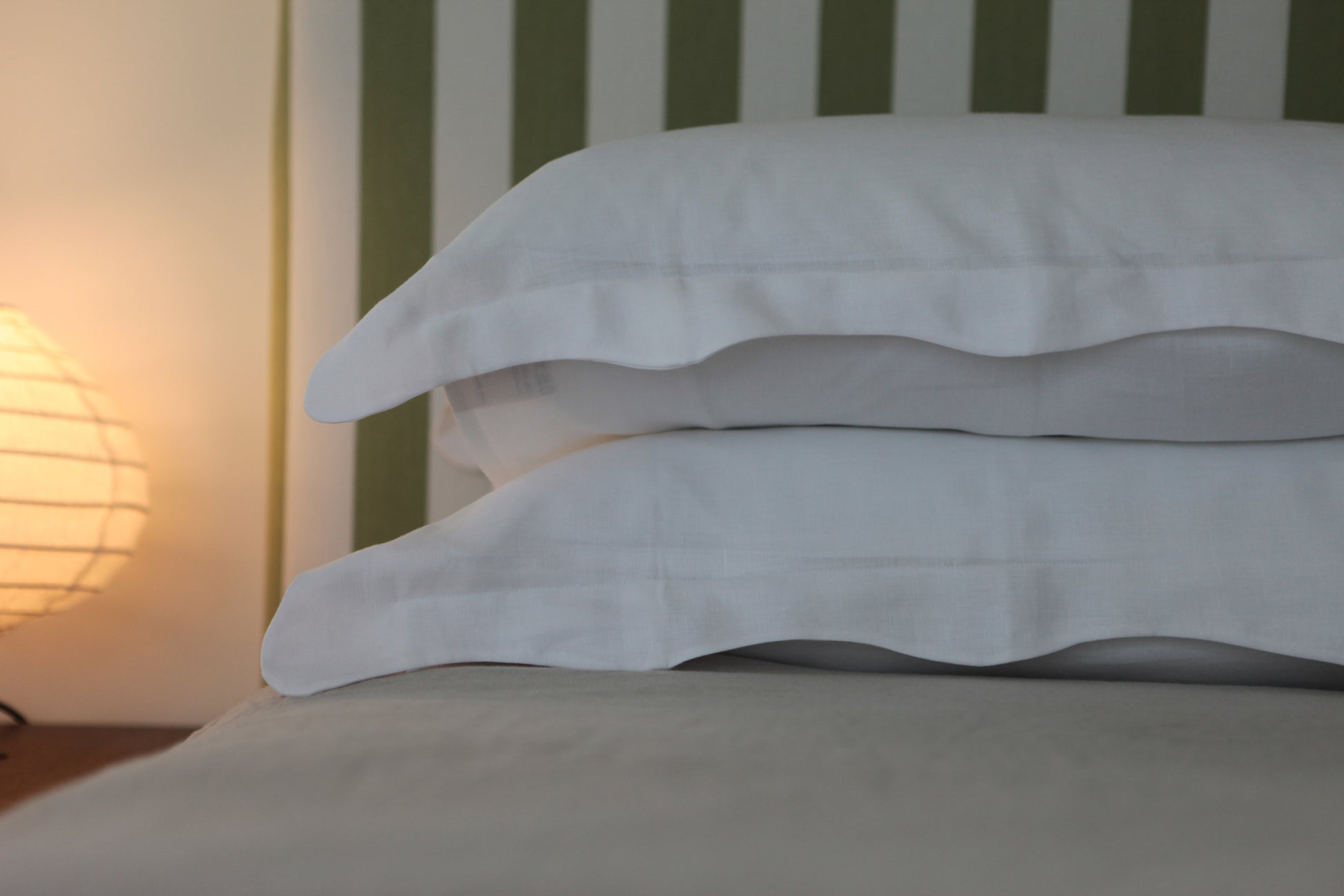 White linen pillowcases with organic wave edge. Light in background. 